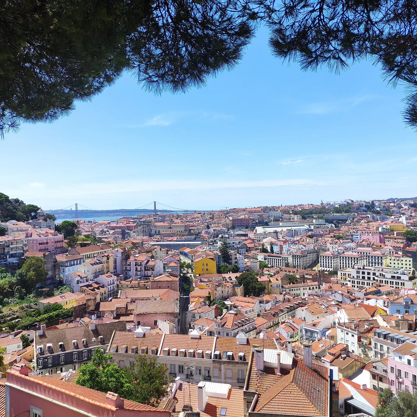 Vista panorâmica sobre os telhados, o Tejo e a Ponte 25 de Abril em Lisboa